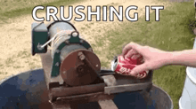 a person is crushing a coke can with a machine .
