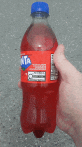 a hand is holding a bottle of fanta strawberry