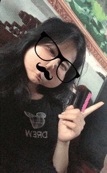 a girl wearing glasses and a fake mustache has the word dream on her t-shirt