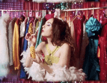 a woman is blowing soap bubbles in front of a closet full of clothes