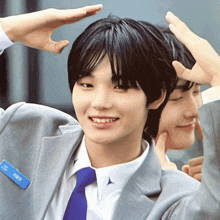 a man in a suit and tie has a name tag that says ' nct dream '
