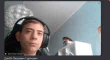 a young man wearing headphones looks at the camera with the name daniil written on the bottom