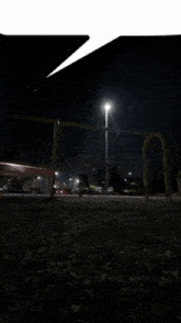 a dark playground at night with a few lights on