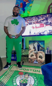 a man playing a video game in front of a boston celtics logo rug