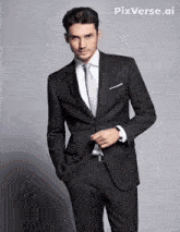 a man in a suit and tie standing with his hands in his pockets