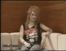 a woman is sitting on a couch wearing a shirt that says michael monroe