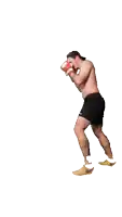 a shirtless man wearing boxing gloves and shorts