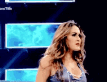 a woman in a blue tank top is standing in front of a sign that says ' women 's title '