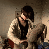 a woman is holding a stuffed animal in her hands