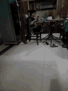 a person sits at a table in a kitchen next to a freezer
