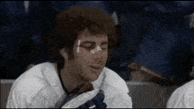 a hockey player with a bandage on his face looks at the camera