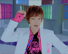 a young man wearing a white jacket and a pink shirt with a star on the sleeve