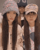 three girls wearing hats one of which has a sticker on it that says ' ehd '