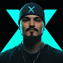 a man with a beard wearing a black beanie with a blue x on it
