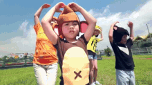 a group of children wearing monkey costumes are dancing in a field