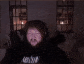 a person is standing in a dark room with a couch in the foreground