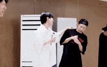 a group of young men are standing next to each other in front of an lg air conditioner