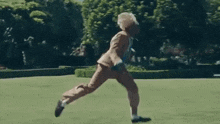 a man in a suit and tie is dancing in a park .