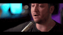 a close up of a man singing into a microphone .