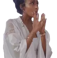 a woman wearing a white robe and a gold bracelet is clapping her hands