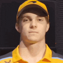 a young man wearing a yellow hat and a yellow shirt looks at the camera .