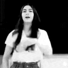 a black and white photo of a woman in a white shirt dancing .