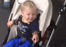 a baby is sitting in a stroller with a blue blanket on .