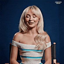 a woman in a blue and white dress is sitting in a chair with her eyes closed and the words addiction sbrina below her