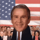 a man in a suit and tie is smiling in front of a large american flag