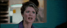 a close up of a woman 's face with a shocked look on her face .