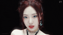 a close up of a woman wearing a choker necklace and earrings .