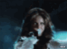 a blurry picture of a woman singing into a microphone with the url rbd.gif