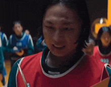a person holding a knife in front of a group of people with the letter m on their jerseys