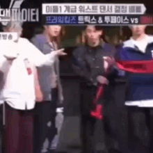 a group of people are standing next to each other in front of a sign that says ' vs ' on it .