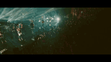 a large crowd of people are watching a band perform on stage