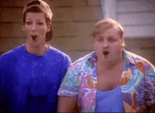 a man and a woman are standing next to each other with their mouths wide open .