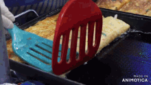 a person is using a spatula to flip a pancake in a pan that says made in animotica