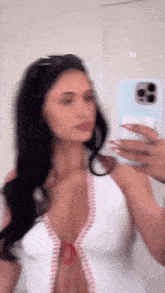 a woman is taking a picture of herself in the mirror .