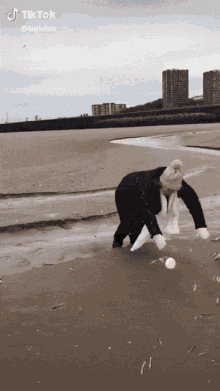 a tik tok video of a person throwing a ball on a beach