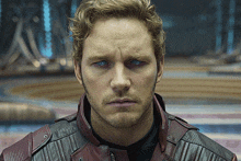 a close up of a man 's face wearing a red leather jacket