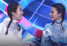 two women are talking to each other with a microphone that says 23