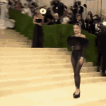 a woman is walking down a set of stairs .