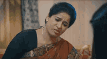 a woman in a saree is talking to another woman in a living room .