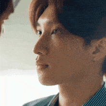 a close up of a man 's face with a woman 's face in the background .