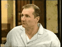 a man in a white shirt is looking to his left
