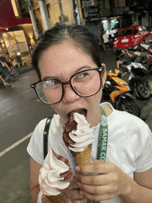 a woman eating an ice cream cone with a lanyard that says samar co on it