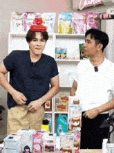 two men standing next to each other in front of a shelf with hygiene products on it