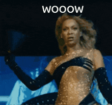 a woman in a black and gold outfit with the word wooow written on the bottom
