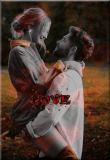 a man is holding a woman in his arms with the word love written in red
