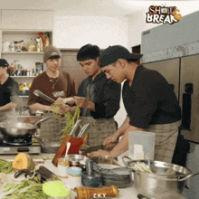 a group of men are preparing food in a kitchen with the words show break on the bottom